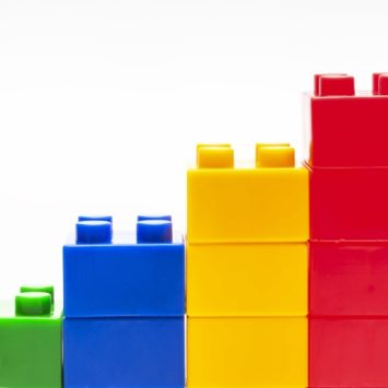 four stacks of colourful children's building blocks, ascending in height