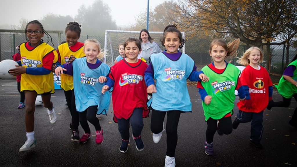 Girls outside in colourful bibs, inspired by Women's World Cup 2023