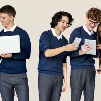 group of school students using laptops and tablets